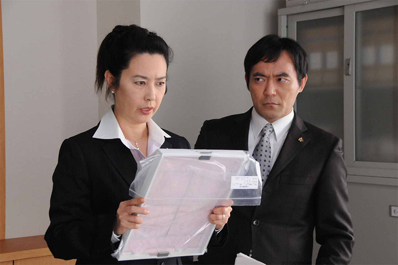 変化した鶴丸(名取裕子)を訝しげに見つめる太田(渡辺いっけい)